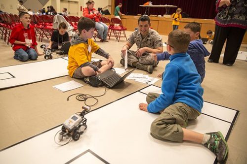 Air Force Capt. Michael K. Kan, center right, interacts with robotics club students during the Department of Defense Education Activity Okinawa’s first robotics competition Feb. 20 at the Camp Foster Community Center, Okinawa, Japan. The competition presented an opportunity for elementary school, middle school and high school robotics students to compete against one another in a friendly environment. Kan is a Brooklyn, N.Y., native and a bioenvironmental engineer with Detachment 2, Bioenvironmental Engineering, 18th Aerospace Medicine Squadron, 18th Medical Group, 18th Wing.